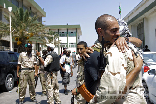 22日，利比亞首都的黎波里，兩名反對派武裝人員擁抱在一起。