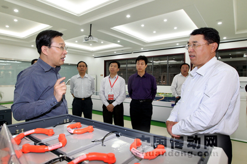 山東電力集團(tuán)總經(jīng)理李同智在展廳向史玉波副主席介紹電動(dòng)公交車(chē)動(dòng)力電池的性能特點(diǎn)